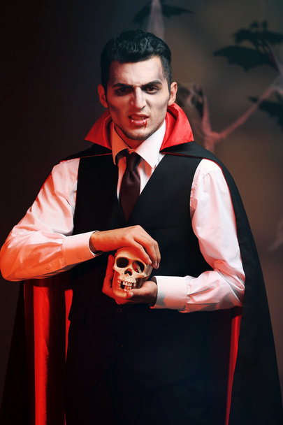 Young man dressed as vampire for Halloween party, on dark background - Fotoğraf, Görsel