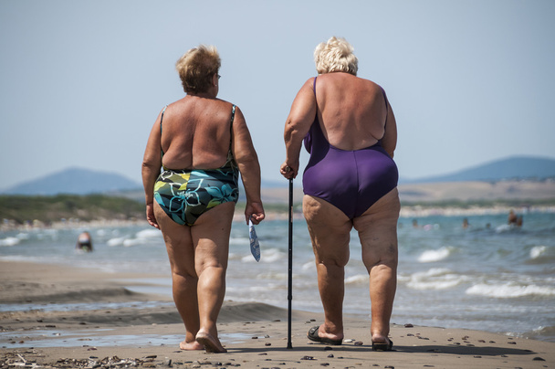 starší a tuku staré dámy chodí na pláži - Fotografie, Obrázek