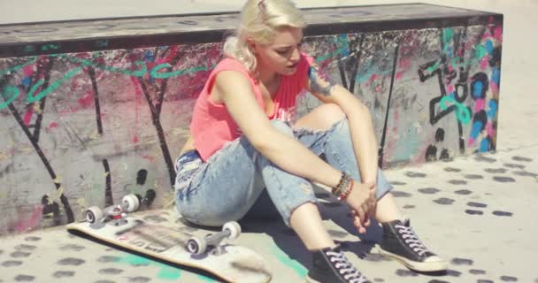 Jovem mulher esperando em um parque de skate para um amigo
 - Filmagem, Vídeo