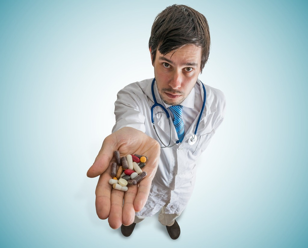 Έννοια της φαρμακευτικής και φαρμακολογίας. Ο γιατρός κατέχει πολλά χάπια στο χέρι. Θέα από την κορυφή. - Φωτογραφία, εικόνα