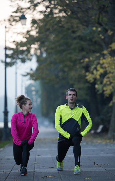 couple warming up before jogging - Photo, Image