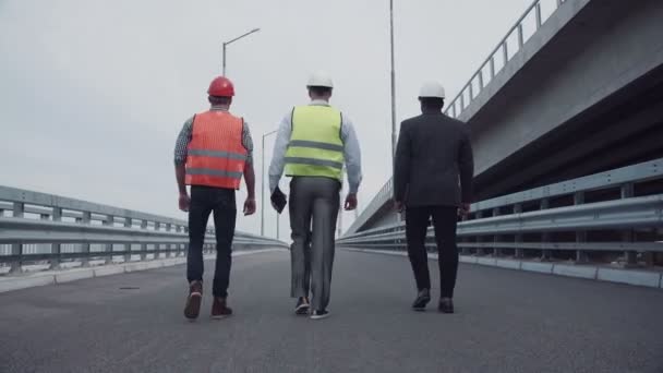 Inżynierowie budowlani spacerują po rampie autostradowych - Materiał filmowy, wideo