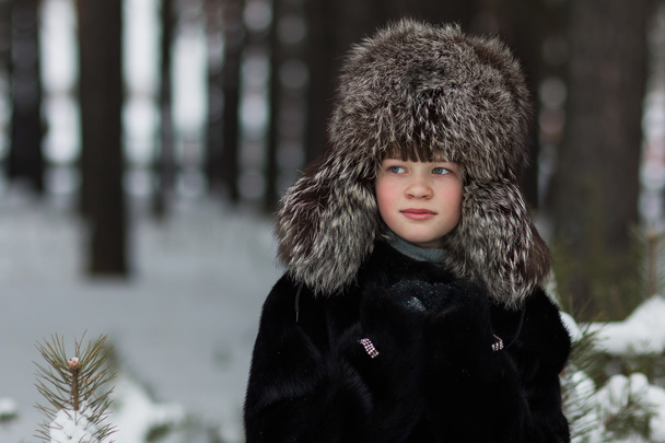 portrait of a girl in a fur hat and fur coat frosty winter day in the forest - Фото, зображення