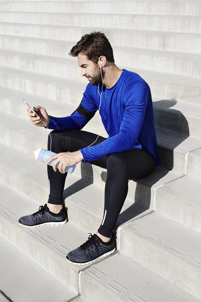 Sporty man looking at smartphone - Photo, image