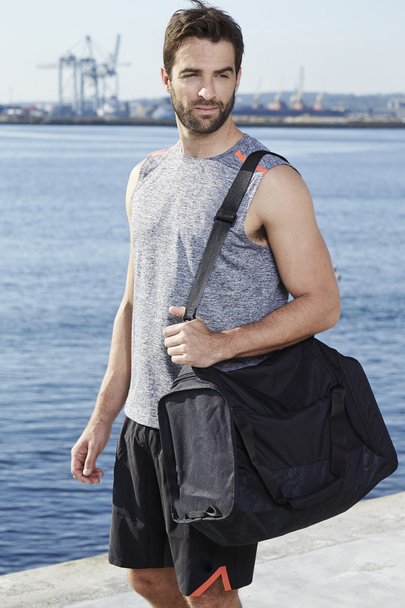 Athlete in vest with sports bag - 写真・画像