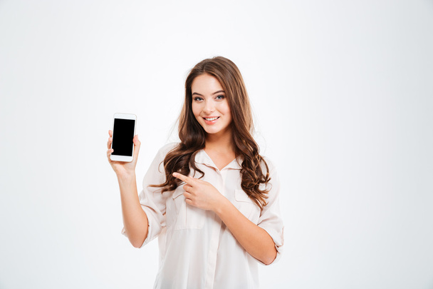 Woman holding blank screen mobile phone and pointing finger - Photo, Image
