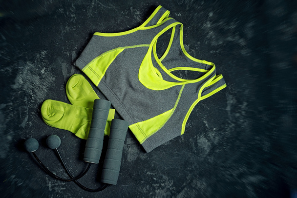 Sports apparel, unusual skipping rope with balls instead of ropes and socks on a dark cement background .Sport and healthy lifestyle concept. Clothing, equipment and fitness accessories. - Φωτογραφία, εικόνα