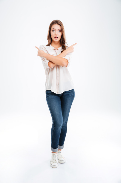 Full length portrait of a happy woman pointing finger away - Photo, image