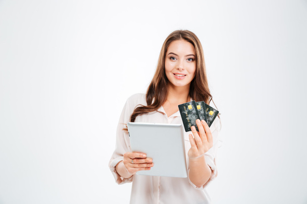 銀行カードやタブレット コンピューターを保持している若い女性を笑顔 - 写真・画像