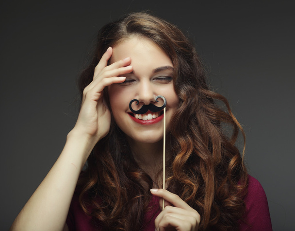 Girl wearing fake mustaches. Ready for party. - 写真・画像