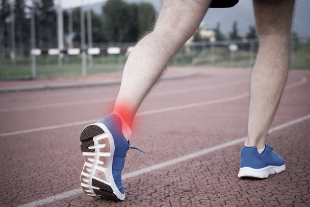 Runner with injured ankle on the track - Φωτογραφία, εικόνα