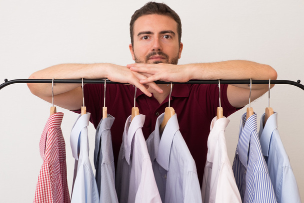 Hombre eligiendo camisas en varios colores y texturas
 - Foto, Imagen