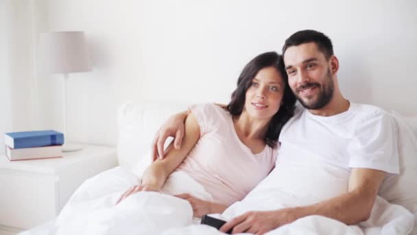 happy couple watching tv in bed at home - Video, Çekim