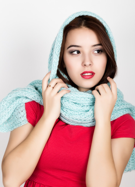 beautiful young woman dressed in a red dress and scarf posing in studio - Fotografie, Obrázek
