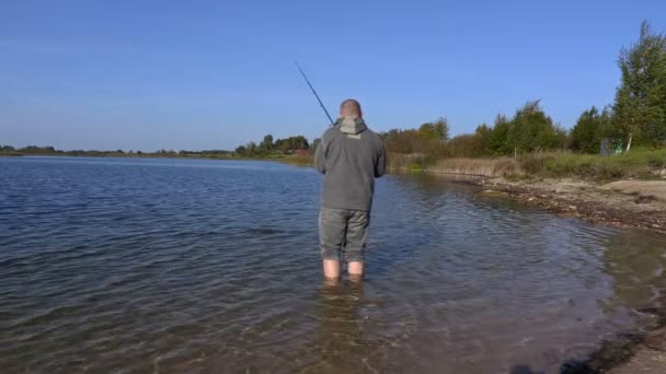 Angler with fishing rod in water - Footage, Video