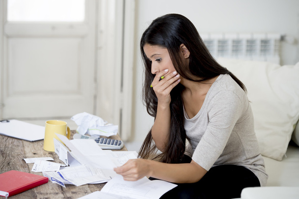 giovane donna latina attraente a casa divano soggiorno calcolando le spese mensili preoccupati per lo stress
 - Foto, immagini