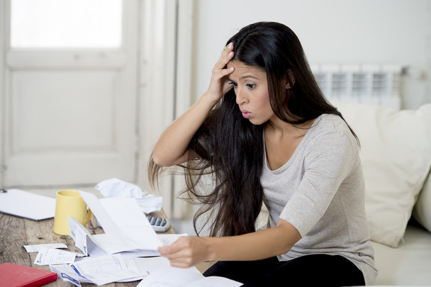 joven atractiva mujer latina en casa sala de estar sofá calcular los gastos mensuales preocupados en el estrés
 - Foto, Imagen