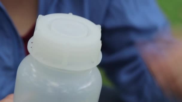 Κοντινό πλάνο στα χέρια του επιστήμονα στο πεδίο ξεβιδώστε καπάκι σε πλαστικό μπουκάλι - Πλάνα, βίντεο