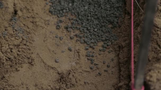 Nahaufnahme von Zement, der in eine Drainage geschaufelt wird - Filmmaterial, Video