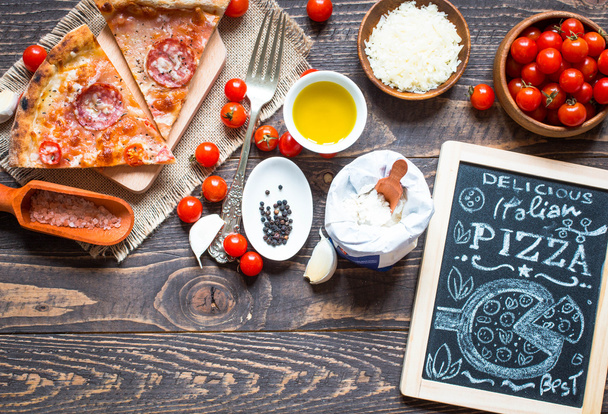 Hot Italian pizza on a rustic wooden table. - Фото, зображення