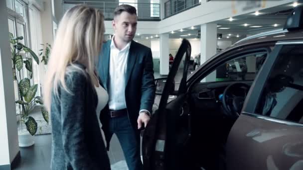 Salesman presenting a new electric car to a customer - Footage, Video
