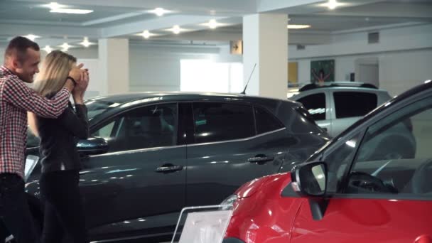 Człowiek, zaskakujące kobieta z nowych samochodów w Show Room - Materiał filmowy, wideo