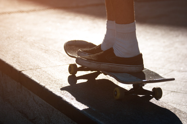 Jambes sur un skateboard
. - Photo, image