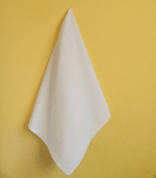Білий Spa рушник висить на жовті стіни - Фото, зображення