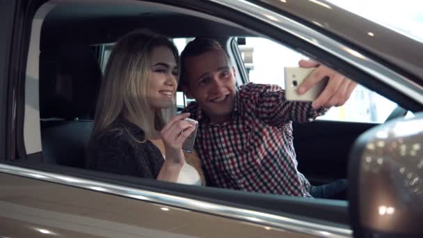 Genç çift yeni bir araba ve yapmak selfie satın alma heyecanlı - Video, Çekim