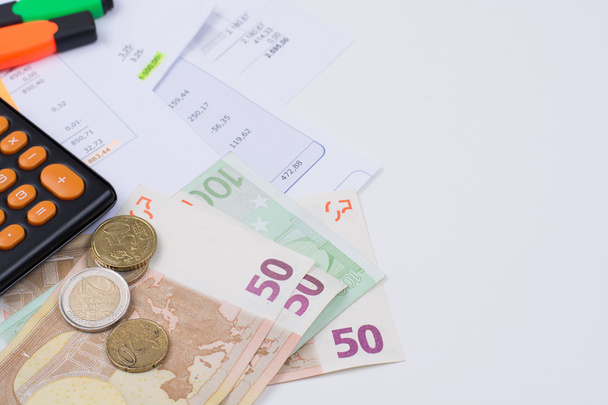 Nut of hypotheek rekeningen, rekenmachine en eurobankbiljetten en munten - Foto, afbeelding
