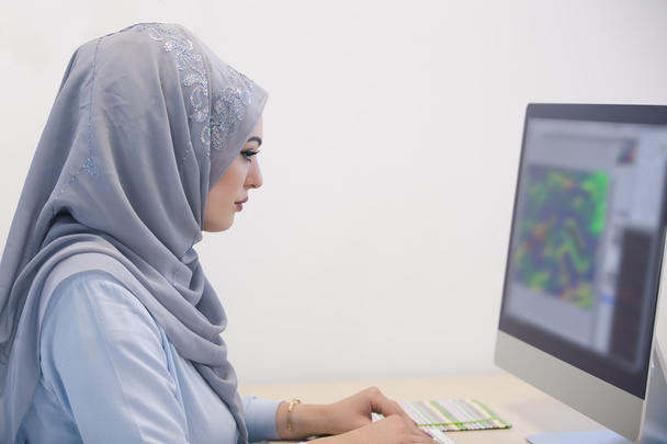 Attractive Muslim woman working in office  - Фото, изображение