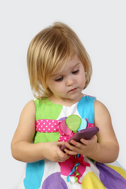 Little girl with cell phone on gray - Valokuva, kuva