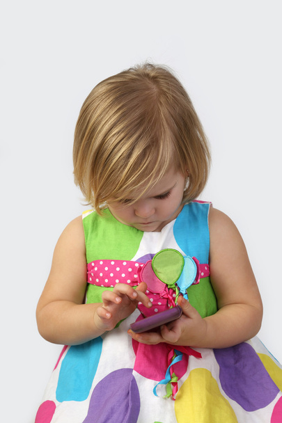 Petite fille avec téléphone portable sur gris
 - Photo, image