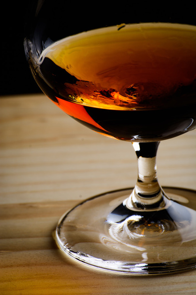Bohemian glass of cognac on a wooden table - Photo, Image