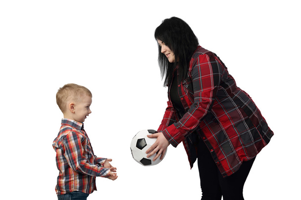 Femme aux cheveux noirs offre un ballon de football pour petit garçon
 - Photo, image