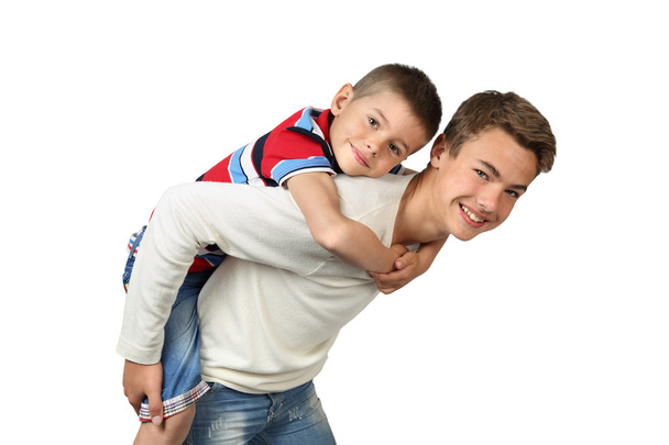 Vanhempi poika kantaa pikkuveljeä selässä
 - Valokuva, kuva