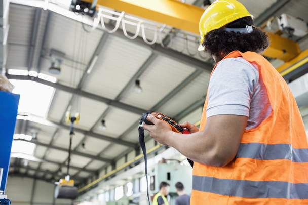 manual worker operating crane in factory  - 写真・画像