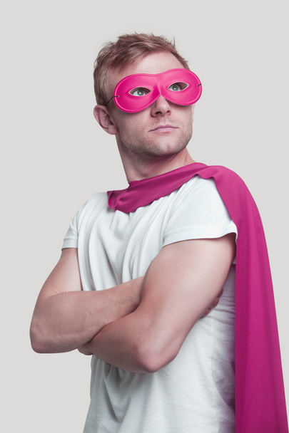 Superhero wearing pink cape and mask  - Foto, afbeelding