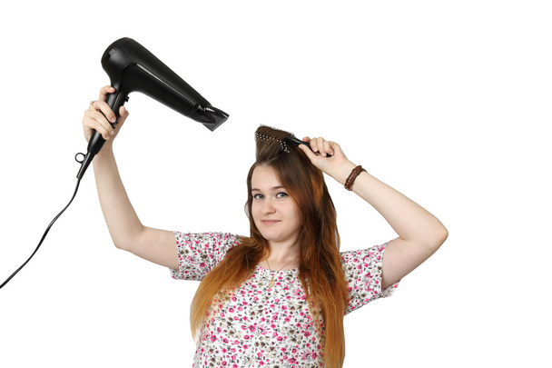Giovane ragazza asciuga i capelli da asciugacapelli
 - Foto, immagini