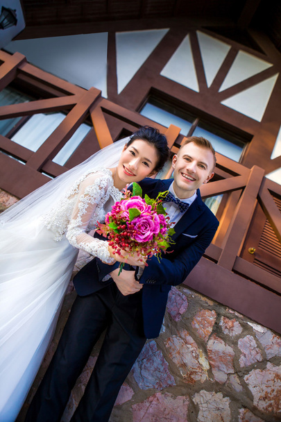 Happy wedding couple holding bouquet - Fotoğraf, Görsel