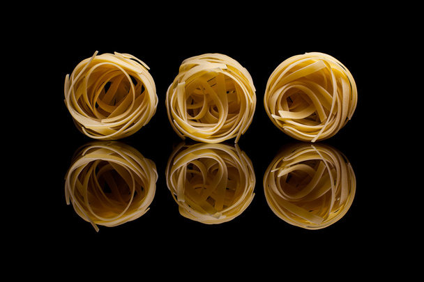 Hnízdo těstoviny na černém pozadí - Fotografie, Obrázek