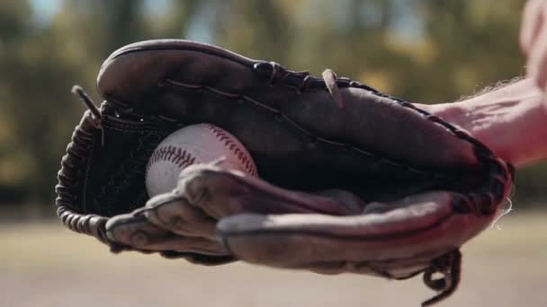Baseballspieler wirft Ball in Handschuh - Filmmaterial, Video