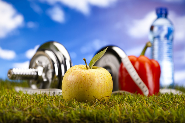 Витамин и фитнес диета, гантели в зеленой траве
 - Фото, изображение
