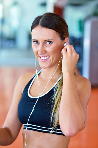 woman putting earphones before exercise - Foto, Imagem