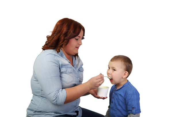 Woman girl feeds little boy - 写真・画像