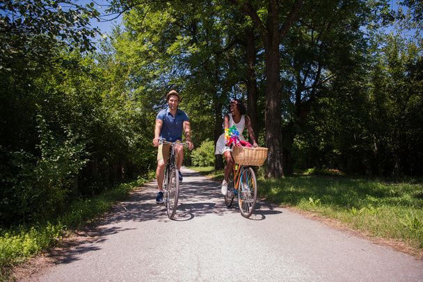 Молодая многонациональная пара, путешествующая на велосипеде по природе
 - Фото, изображение