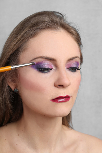 Young pretty woman shows makeup - Φωτογραφία, εικόνα