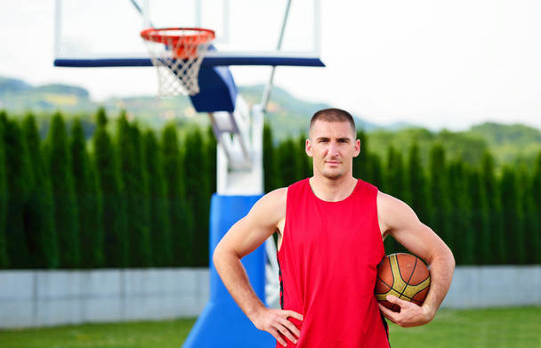 Basketball player with ball at the outdoors basket court - Fotografie, Obrázek