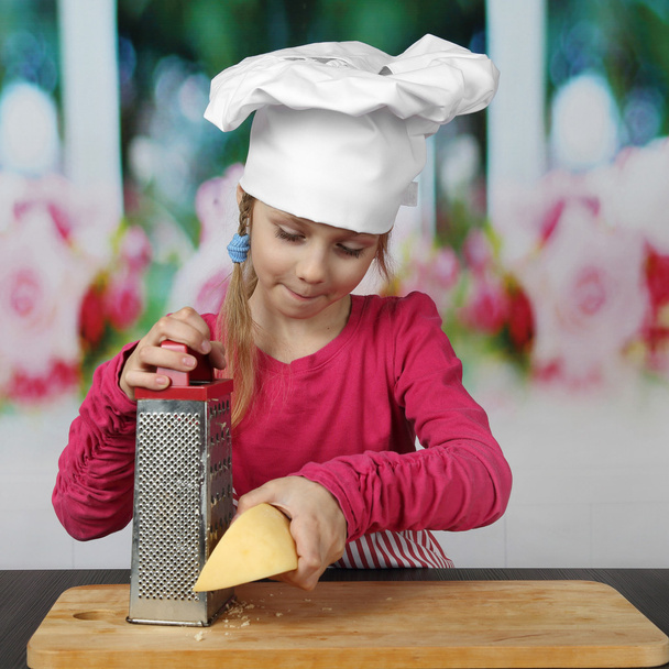 Joung cook grates cheese - Photo, Image