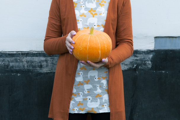 Woman holding orange pumpkin in hands - Foto, Bild